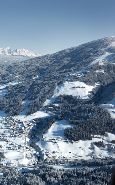 Bird’s eye view of Wagrain with surrounding winter landscape and view towards Flachau at Snow Space Salzburg | © Bergbahnen AG Wagrain