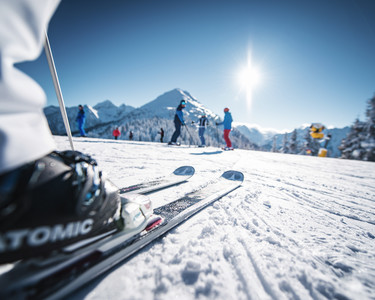 Skifahrer genießen einen sonnigen Wintertag im Skigebiet Snow Space in Salzburg
