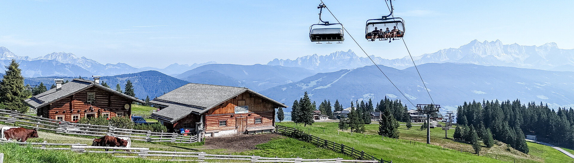 The Starjet mountain lift with a view of a mountain pasture with cows and mountains in Flachau The Starjet mountain lift with a view of a mountain pasture with cows and mountains in Flachau from Snow Space Salzburg