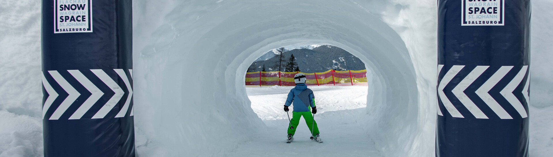 Child drives through snow tunnel at the Kidsrun in Flachau snow space Salzburg 