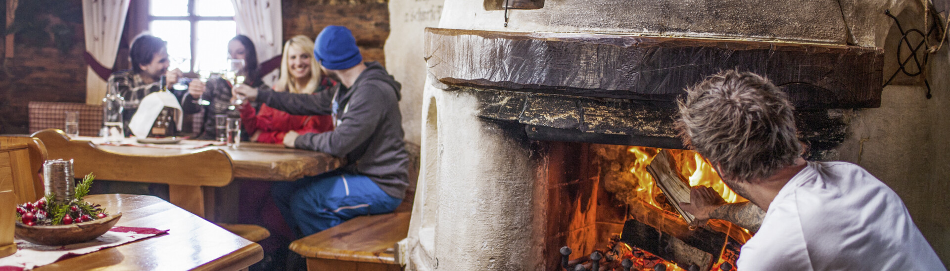 Ski group in the ski hut with drinks and open fire