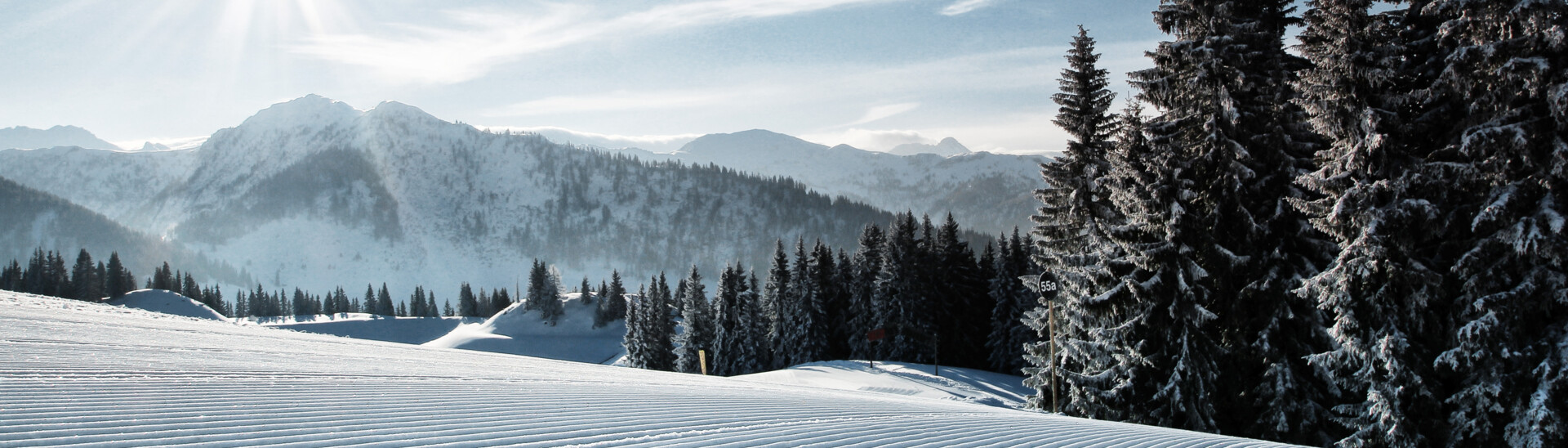 Blick auf die frisch präparierten Pisten des Skigebiets St. Johann bei Sonnenshine