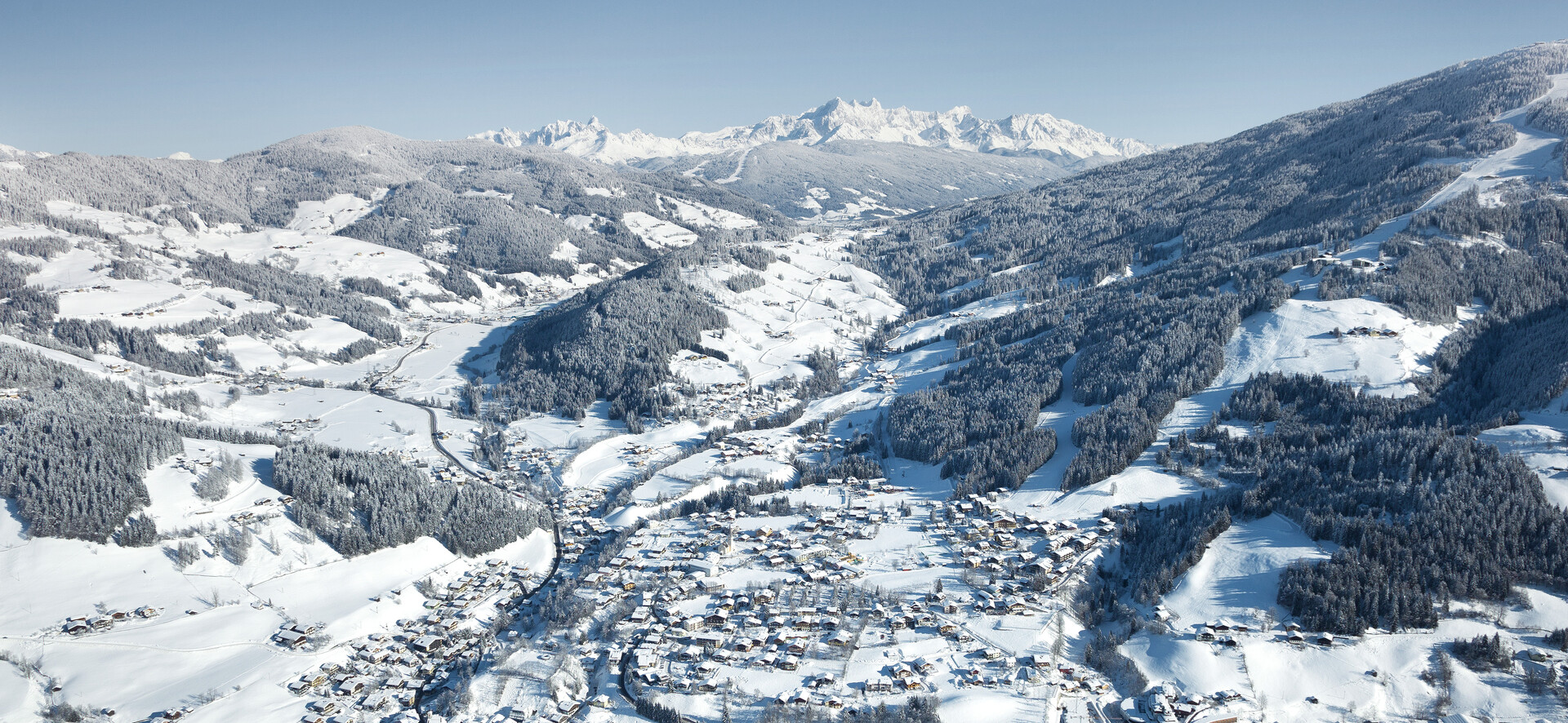 Bird’s eye view of Wagrain with surrounding winter landscape and view towards Flachau at Snow Space Salzburg | © Bergbahnen AG Wagrain