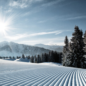 Blick auf die frisch präparierten Pisten des Skigebiets St. Johann bei Sonnenshine