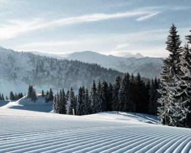 Blick auf die frisch präparierten Pisten des Skigebiets St. Johann bei Sonnenshine