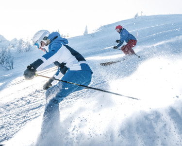 Zwei Skifahrer ziehen ihre Schwünge über die perfekt präparierten Pisten im Skigebiet Snow Space Salzburg | © Ski amadé