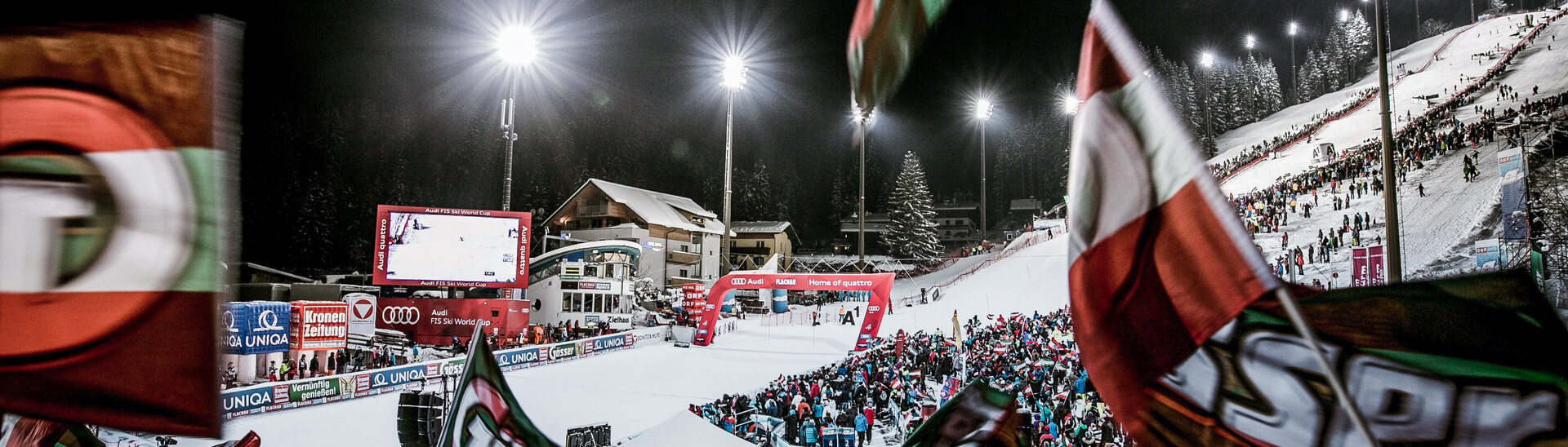 The annual Audi FIS Alpine Ski World Cup women’s night slalom in Flachau is a thrilling spectacle for skiing fans. | © Skiweltcup Flachau Cheering spectators in the finish area of the Audi FIS Alpine Ski World Cup women’s night slalom with the Hermann Maier World Cup racetrack in the background | © Skiweltcup Flachau