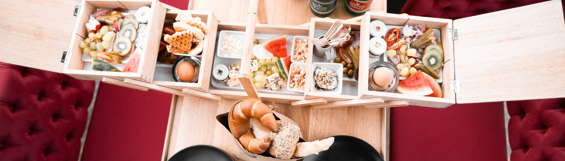 Ein appetitlich angerichtetes Buffet auf einer hölzernen Servierplatte mit verschiedenen Gerichten in einem gemütlichen Gastraum im Snow Space Salzburg