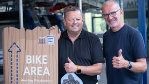 Zwei Männer geben Daumen hoch bei der Bike Area Mittelstation in Snow Space Salzburg.