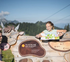 A girl laughs while standing at an interactive station on an educational trail at Snow Space Salzburg